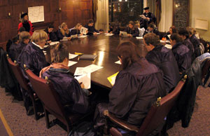 students wearing academic gowns around a table